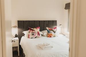 Una cama blanca con almohadas rosas y toallas. en The Mill Apartments Clare Valley en Clare