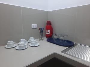 un mostrador de cocina con tazas y platillos. en Hospedaje Margarita, en La Merced