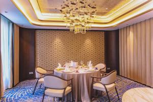 a dining room with a table and chairs and a chandelier at Radisson Collection Hotel, Yangtze Shanghai in Shanghai