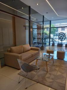 a living room with a couch and a glass table at Jade Barrio Sur A Estrenar by Citrino Aparts in San Miguel de Tucumán