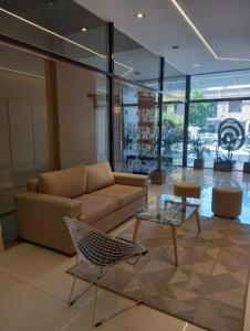 Una sala de estar con un sofá y una mesa de cristal. en Jade Barrio Sur A Estrenar by Citrino Aparts, en San Miguel de Tucumán