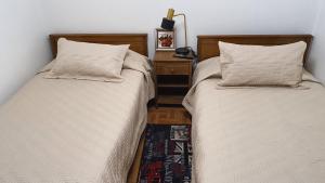 twee bedden naast elkaar in een slaapkamer bij Hostal Costa Brava in Iquique