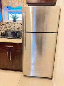 a stainless steel refrigerator in a kitchen with a microwave at ZEN RETREAT in Brooklyn