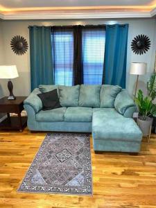 a living room with a blue couch and a rug at ZEN RETREAT in Brooklyn