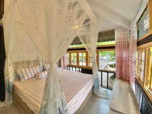 1 dormitorio con cama con dosel y mosquiteras en Chung cư 47 BACU - Bãi trước Vũng Tàu en Vung Tau