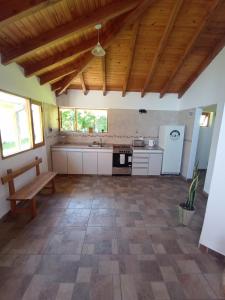 une grande cuisine avec un plafond en bois et un banc dans l'établissement La Casita, à Esquel