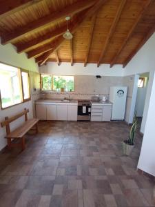 a large kitchen with a wooden ceiling and a bench at La Casita in Esquel +16 photos