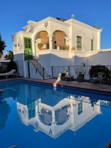 uma casa branca com uma piscina em frente em Serena Vista em Álamos