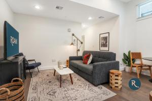 a living room with a couch and a tv at Roami at Bourbon Place in New Orleans