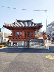a wooden building with a roof on a street at J.Hill House in Seoul
