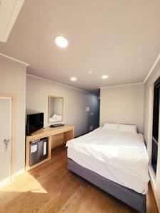 1 dormitorio con 1 cama grande y TV en J.Hill House en Seúl