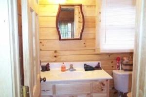 a bathroom with a sink and a mirror at Alpenhaus Cabins Real Log Home in Helen Ga Mountains with hot tub and balconies in Sautee Nacoochee