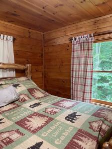 ein Schlafzimmer mit einem Bett in einem Blockhaus in der Unterkunft Alpenhaus Cabins Real Log Home in Helen Ga Mountains with hot tub and balconies in Sautee Nacoochee