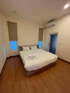 um quarto com uma grande cama branca com dois copos em The PaVillu de Pool Villas em Samut Songkhram