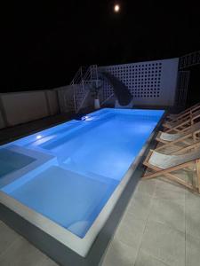 a large swimming pool with blue lights on it at The PaVillu de Pool Villas in Samut Songkhram