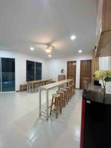 uma cozinha com uma mesa longa e cadeiras num quarto em The PaVillu de Pool Villas em Samut Songkhram