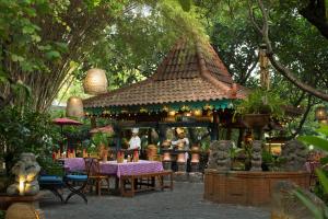 a restaurant with a table and chairs in a garden at Bumi Surabaya City Resort in Surabaya