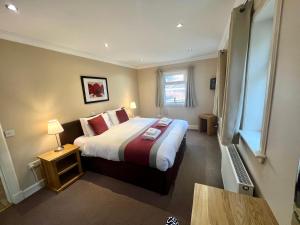 a hotel room with a large bed and a window at Glenachulish Bay with Hot Tub in Glencoe
