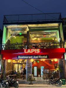 a restaurant with motorcycles parked outside of it at night at Lapis Restaurant and Hostel in Vũ Lâm