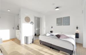 a bedroom with white walls and a bed in it at Cozy Apartment In Lembruchdümmer See in Lembruch