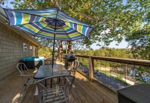 une table et des chaises sur une terrasse avec un parasol dans l'établissement Douglas Lake House with Private Hot Tub by Staycating, à Sevierville