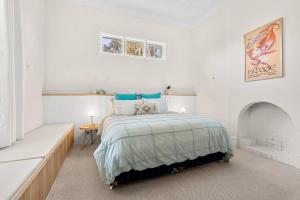 - une chambre blanche avec un lit et une cheminée dans l'établissement Piambong House, à Clare