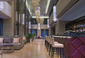 a lobby with chairs and a bar in a building at The Westin Qingdao - Instagrammable in Qingdao