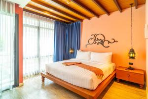 a bedroom with a large bed with orange walls at Amber Boutique Silom in Bangkok