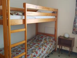 ein Schlafzimmer mit zwei Etagenbetten und einem Bett in der Unterkunft Notre-Dame-de-Monts (85) - Appartement de vacances 55m² environ - 5 personnes - FR-1-540-147 in Notre-Dame-de-Monts
