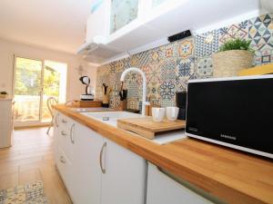 - une cuisine avec un comptoir et une télévision dans l'établissement Saint Cyprien - T2 avec Balcon, Climatisation et Parking à 2 Pas du Port - FR-1-309-305, à Saint-Cyprien