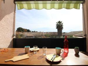 una mesa con una botella y gafas y una ventana en Appartement Saint-Cyprien, 2 pièces, 4 personnes - FR-1-309-353, en Saint-Cyprien