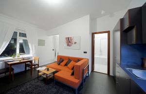 a living room with an orange couch and a table at Astro Apartments in Reykjavík
