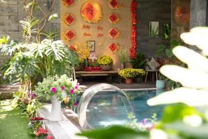 a swimming pool in a garden with flowers and plants at Royal 98 Hotel & Apartment in Da Nang