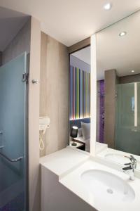 ein Bad mit einem Waschbecken und einem Spiegel in der Unterkunft Ibis Styles Jakarta Mangga Dua Square in Jakarta