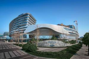 un grand bâtiment avec un panneau devant lui dans l'établissement Primus Hotel Shanghai Hongqiao, à Shanghai