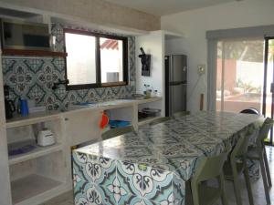 a kitchen with a table with chairs and a counter top at Casa Tulup Sisal in Sisal