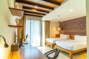 a hotel room with two beds and a table at Amber Boutique Silom in Bangkok