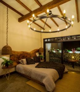 a bedroom with a large bed and a chandelier at El Rio Hotel in Doradal