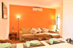 sala de estar con paredes de color naranja y sofá en Casa Palma, en La Paz