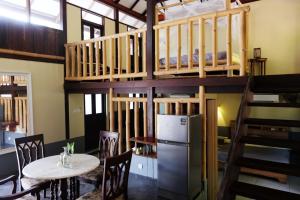 a room with a bunk bed and a table and chairs at Bamboo Cottage Langkawi in Pantai Cenang