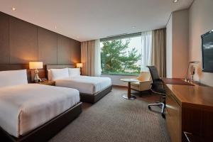 a hotel room with two beds and a desk at LOTTE City Hotel Gimpo Airport in Seoul +37 photos