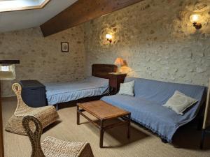 Habitación con 2 camas, sofá y silla en Gîte Bonnes, 5 pièces, 12 personnes - FR-1-653-122, en Bonnes