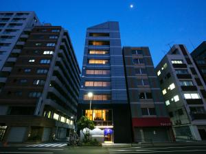 dois edifícios altos numa cidade à noite em COCOSHUKU Asakusa Kuramae em Tóquio