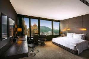 深セン市にあるShenzhen O Hotelのベッド、デスク、椅子が備わるホテルルームです。