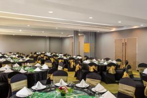 a banquet hall with tables and chairs with people in it at KHAS Tegal Hotel in Tegal