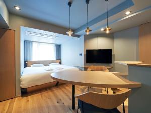 a bedroom with a bed and a table and a tv at COCOSHUKU AKASAKA Premium in Tokyo