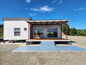 a tiny house with a porch and a deck at TANJUNG GROVE VILLAS 