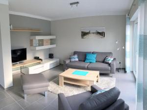 ein Wohnzimmer mit einem Sofa und einem Tisch in der Unterkunft Haus am Meer Ferienwohnung Deluxe in Dangast