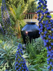 a large blue vase in a garden with blue flowers at Rent your own Historic Hotel for Holidays & Events in Maldon