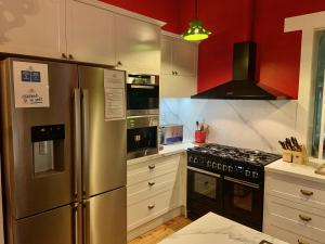 a kitchen with a stainless steel refrigerator and red walls at Rent your own Historic Hotel for Holidays & Events in Maldon